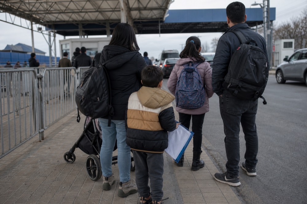Family with passports at border checkpoint, no text, no logos, no people