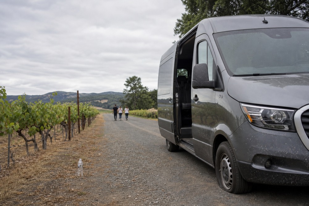 Private tour van parked on a rural road in Baja California wine country, no text, no logos, no people